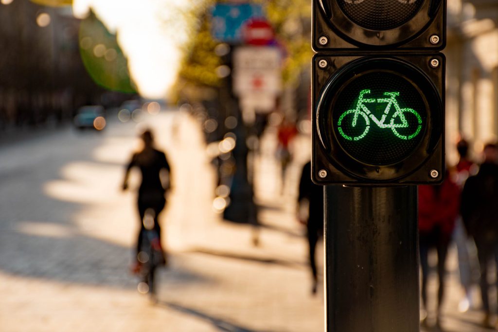 Green bicycle traffic light with a cyclist in the city