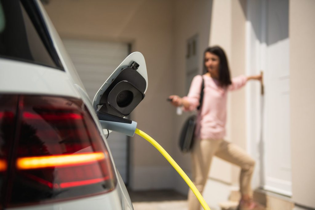 Woman charging an electric car at home