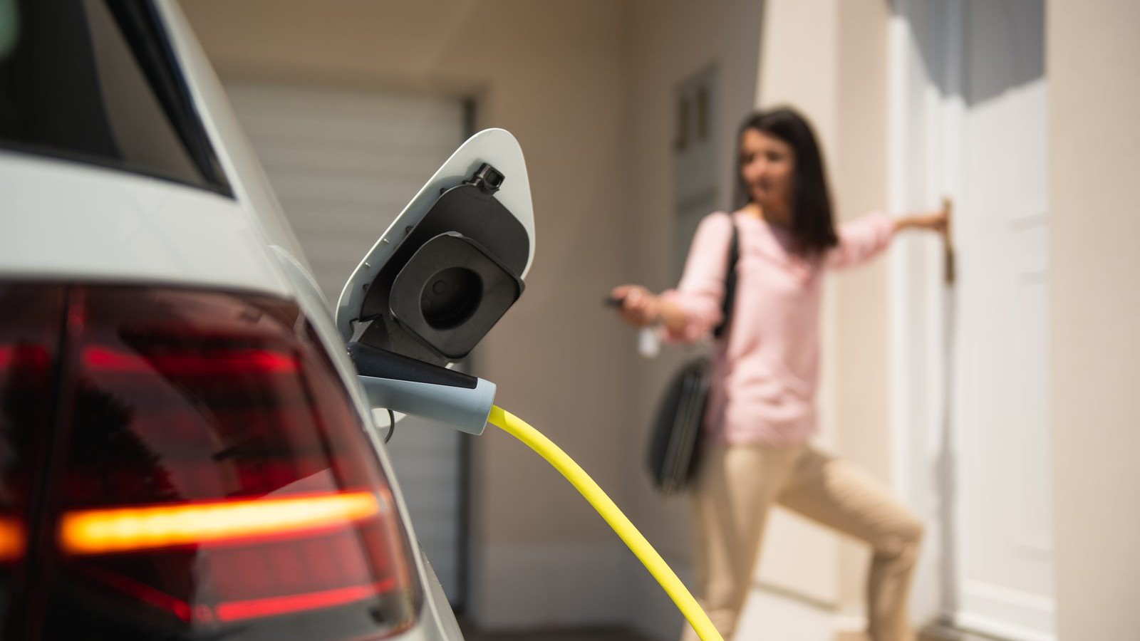 Woman charging an electric car at home
